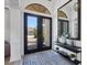 Stylish foyer featuring a black framed mirror, decor, patterned rug, and a view to the paver driveway at 7024 Brier Creek Ct, Lakewood Ranch, FL 34202