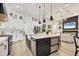 A modern kitchen with stainless steel appliances, white cabinets, and a large island at 7024 Brier Creek Ct, Lakewood Ranch, FL 34202