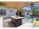 Inviting outdoor kitchen with bar seating, pergola, pool view, and access to the back of the house at 7024 Brier Creek Ct, Lakewood Ranch, FL 34202