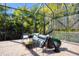 Relaxing screened lanai featuring comfortable seating and views of the lush tropical landscaping at 7024 Brier Creek Ct, Lakewood Ranch, FL 34202