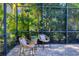 Inviting screened lanai featuring wicker chairs, pillows and view of the lush tropical landscaping at 7024 Brier Creek Ct, Lakewood Ranch, FL 34202