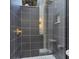 Modern shower with gray tile, built-in niche, and gold hardware at 7024 Brier Creek Ct, Lakewood Ranch, FL 34202
