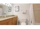 Well-lit bathroom featuring granite counters, wood cabinetry, and a shower/tub with curtain at 8043 St Simons St, Bradenton, FL 34201