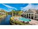 Community pool overlooks canal and townhomes with lounge seating and palm trees against a blue sky at 8043 St Simons St, Bradenton, FL 34201