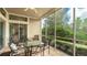 Screened in porch with tile flooring and outdoor dining table and chairs with green view at 8043 St Simons St, Bradenton, FL 34201