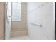 Tiled walk-in shower with glass block window, bench, and safety bar at 8043 St Simons St, Bradenton, FL 34201