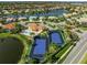 A beautiful aerial view showcases the community's pool, tennis courts, and lush landscaping near the lake at 8294 Barton Farms Blvd, Sarasota, FL 34240