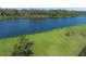 The verdant backyard is shown leading to the tranquil lake at 8294 Barton Farms Blvd, Sarasota, FL 34240