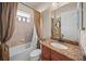 Bathroom featuring granite countertops, tile walls, shower-tub combo, and neutral ceramic tile flooring at 8294 Barton Farms Blvd, Sarasota, FL 34240