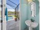 A bathroom sink sits next to the view of a private pool and screened lanai at 8294 Barton Farms Blvd, Sarasota, FL 34240