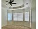 Spacious bedroom featuring a ceiling fan, tray ceiling, and three windows with blinds at 8294 Barton Farms Blvd, Sarasota, FL 34240