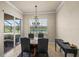 Bright dining room with chandelier, lake view, and sliding glass doors to outdoor seating area at 8294 Barton Farms Blvd, Sarasota, FL 34240