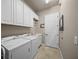 Laundry room with white cabinets, a utility sink, washer, and dryer, creating an efficient space at 8294 Barton Farms Blvd, Sarasota, FL 34240
