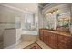 Bright main bathroom featuring a soaking tub, a separate glass shower and dual sinks at 8294 Barton Farms Blvd, Sarasota, FL 34240