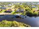Aerial view of waterfront home and boat dock with neighborhood in background at 9332 Miami Cir, Port Charlotte, FL 33981