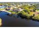 An aerial view of the waterfront home, boat dock, screened lanai, and surrounding neighborhood at 9332 Miami Cir, Port Charlotte, FL 33981