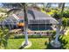 Aerial view of backyard, screened lanai with pool, landscaping, and palm trees at 9332 Miami Cir, Port Charlotte, FL 33981