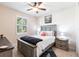 Comfortable bedroom features a ceiling fan, window with blinds, and stylish furnishings at 9332 Miami Cir, Port Charlotte, FL 33981
