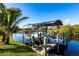 Private dock on a serene canal with lush landscaping and boat lift at 9332 Miami Cir, Port Charlotte, FL 33981