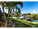 Waterfront home featuring a private dock with boat lift and lush tropical landscaping at 9332 Miami Cir, Port Charlotte, FL 33981