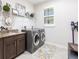 A modern laundry room with granite countertop, cabinets, washer, and dryer at 9332 Miami Cir, Port Charlotte, FL 33981