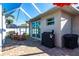 Outdoor patio with covered enclosure, sliding doors, grill and seating area at 9332 Miami Cir, Port Charlotte, FL 33981