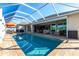 Screen enclosed pool with sun shelf, patio furniture, and open access to the home's interior at 9332 Miami Cir, Port Charlotte, FL 33981