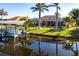 Waterfront property features a boat dock with lift, lush landscaping, and screened lanai for enjoying the outdoors at 9332 Miami Cir, Port Charlotte, FL 33981
