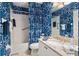 Well-lit bathroom with decorative blue wallpaper and a sink with granite countertop at 9630 Club South Cir # 6208, Sarasota, FL 34238