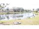 Scenic view of a calm pond surrounded by lush trees and well-maintained landscaping at 9630 Club South Cir # 6208, Sarasota, FL 34238
