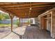 Covered back porch with wood decking and exposed beams, offering a charming outdoor space at 1004 12Th W Ave, Palmetto, FL 34221