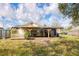 Home featuring a back deck overlooking a large backyard with mature trees and blue skies at 1004 12Th W Ave, Palmetto, FL 34221