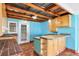 This kitchen features natural wood cabinets, terra cotta tile floors, and blue-painted wood walls at 1004 12Th W Ave, Palmetto, FL 34221