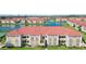 Aerial view of a lakeside condo complex featuring red tile roofs, lush landscaping, and community amenities at 1005 Villagio Cir # 106, Sarasota, FL 34237