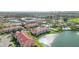 Aerial view of the condo community featuring a lake, pool, tennis courts, and manicured lawns at 1005 Villagio Cir # 106, Sarasota, FL 34237