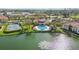 Scenic aerial view of clubhouse, pool, and fountain on a tranquil lake within a residential community at 1005 Villagio Cir # 106, Sarasota, FL 34237