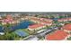 Beautiful aerial view of the condo complex with a tennis court, lake, and red-tiled roofs at 1005 Villagio Cir # 106, Sarasota, FL 34237