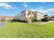 Well-maintained condo complex with lush lawns and a serene lakeside setting under a clear sky at 1005 Villagio Cir # 106, Sarasota, FL 34237