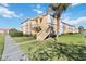 Attractive condo building with lush landscaping and a paved walkway, set beneath a sunny sky at 1005 Villagio Cir # 106, Sarasota, FL 34237