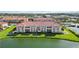 Beautiful condo building overlooking a pond with lush green landscaping and a red tile roof at 1005 Villagio Cir # 106, Sarasota, FL 34237