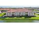 Exterior of condo building with neutral paint, red roof tiles, and pond view at 1005 Villagio Cir # 106, Sarasota, FL 34237