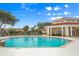 Enjoy this luxurious community pool area on a sunny day with plenty of lounge chairs and umbrellas at 1005 Villagio Cir # 106, Sarasota, FL 34237