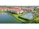 Aerial view of a community featuring tennis courts, lake, and residential buildings with red roofs at 1005 Villagio Cir # 106, Sarasota, FL 34237