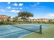 Well-maintained tennis court with blue surface and green surroundings in a peaceful residential area at 1005 Villagio Cir # 106, Sarasota, FL 34237