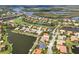 Aerial view of a residential area surrounded by water, a golf course, and lush greenery at 10509 Winding Stream Way, Bradenton, FL 34212
