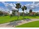 A nicely landscaped backyard with mature palm trees, green grass, and a black metal fence for privacy at 10509 Winding Stream Way, Bradenton, FL 34212