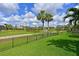 Backyard with well-maintained lawn, golf course views, a lake and a secure black metal fence at 10509 Winding Stream Way, Bradenton, FL 34212