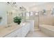 Elegant bathroom with double sinks, glass shower, arched windows and soaking tub at 10509 Winding Stream Way, Bradenton, FL 34212
