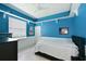 Bright blue bedroom with white trim, shelving for display, and a comfortable bed at 10509 Winding Stream Way, Bradenton, FL 34212
