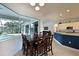 Dining area overlooking a screened-in patio and pool with a view into the open kitchen at 10509 Winding Stream Way, Bradenton, FL 34212